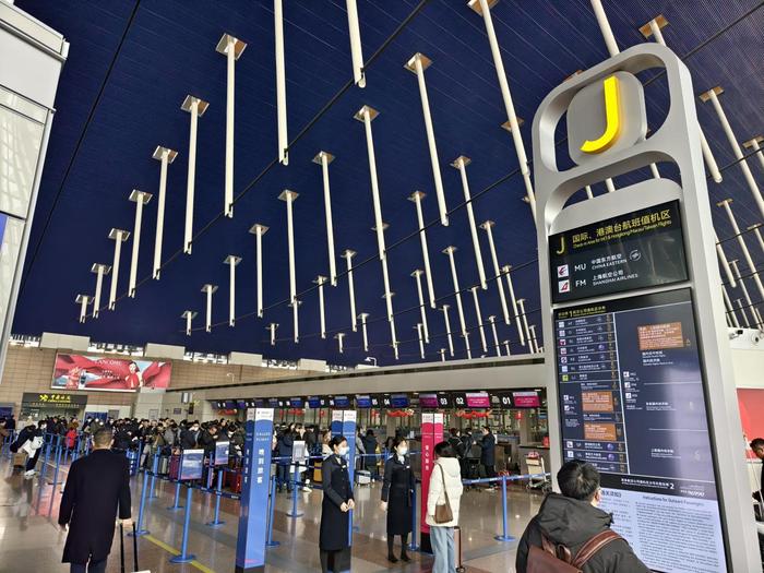 在浦东机场J岛，乘坐东航国际航班的旅客正在办理值机手续