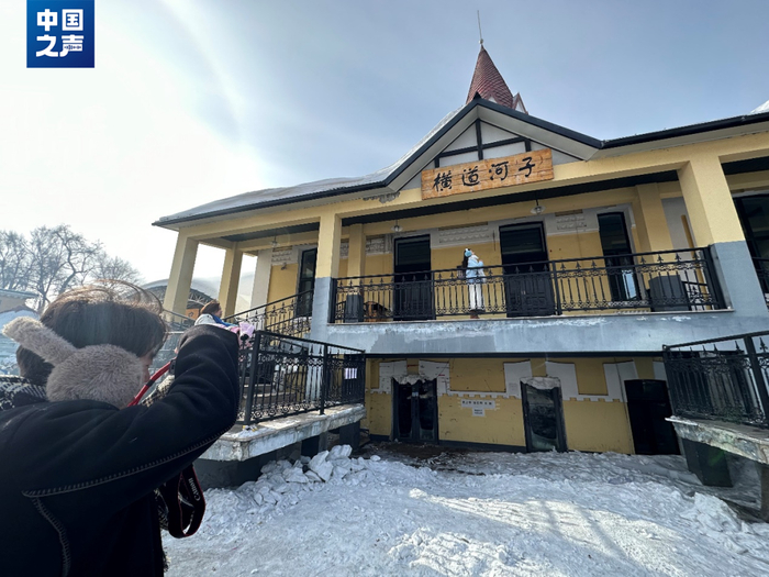 △在站前拍照的游客们（记者韩雪莹 摄）