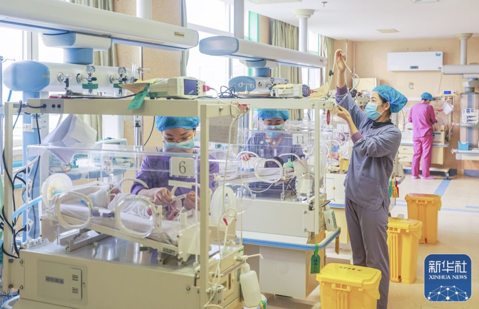 2月10日，山东省荣成市妇幼保健院新生儿重症监护病房，医护人员在对新生儿患者进行医疗护理。新华社发（李信君 摄）