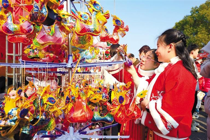         图为2月10日，两名小朋友在南京夫子庙花灯市场挑选龙灯。    新华社发（苏阳 摄）    