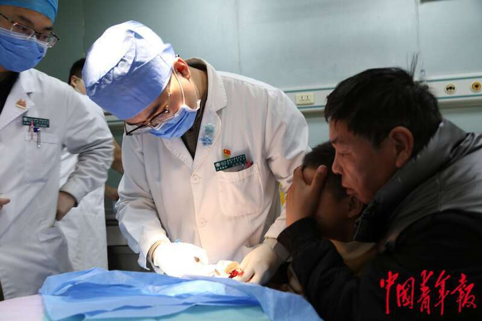 2月6日晚，北京儿童医院急诊外科医生正在给患儿处理手部伤口。中青报•中青网记者 刘昶荣/摄