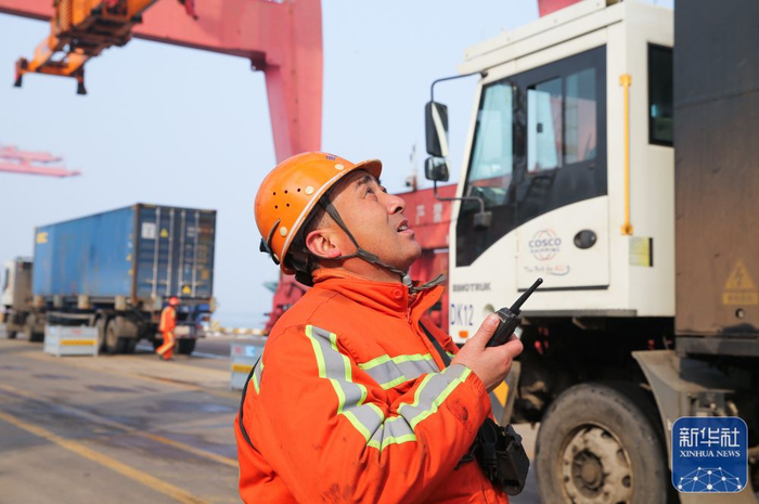 2月9日，工人在江苏连云港港集装箱码头吊装货物。新华社发（王健民 摄）