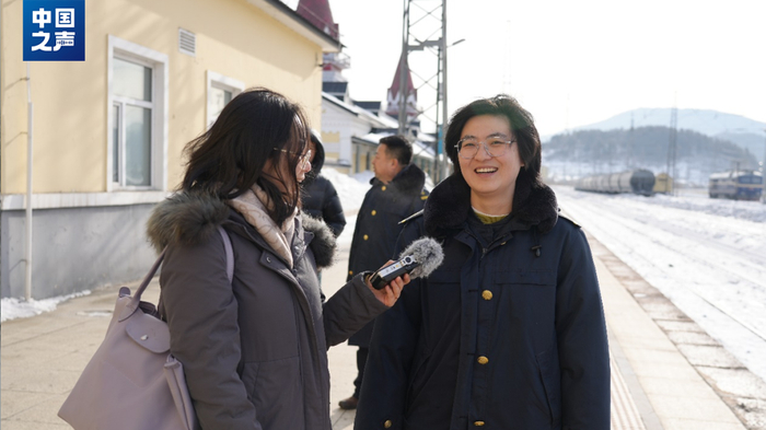 △横道河子站客运负责人徐烨（右）在站台迎接旅客