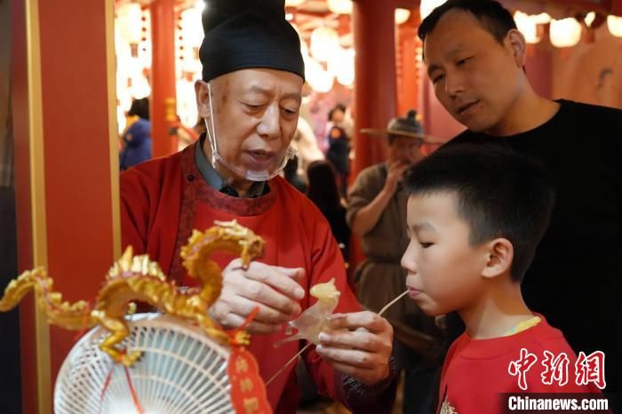 图为儿童在街区内体验民俗。长安十二时辰主题街区供图