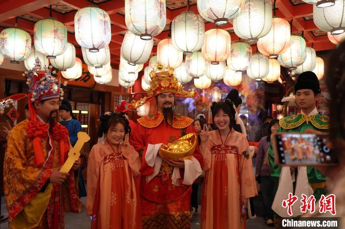 图为游客与“财神”在街区内互动。长安十二时辰主题街区供图