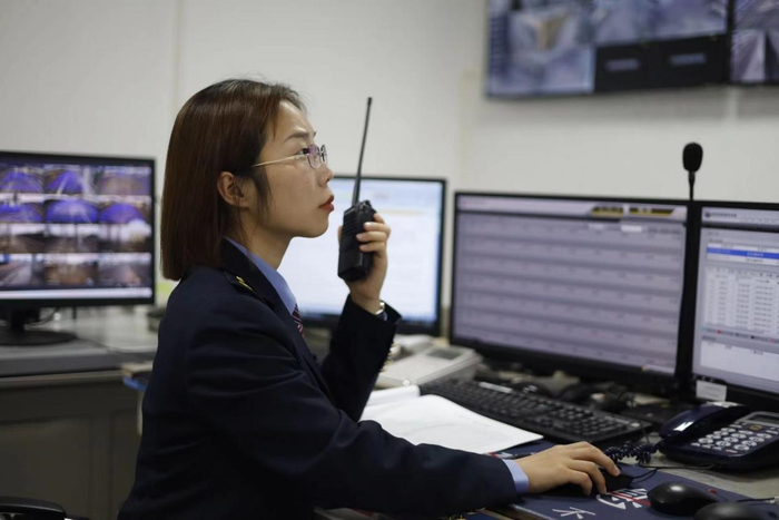 张华正在使用对讲机沟通客运工作情况.蔡紫妍摄