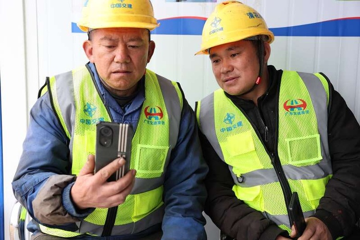 清花高速彝族兄弟在和家人通话。广东交通集团供图