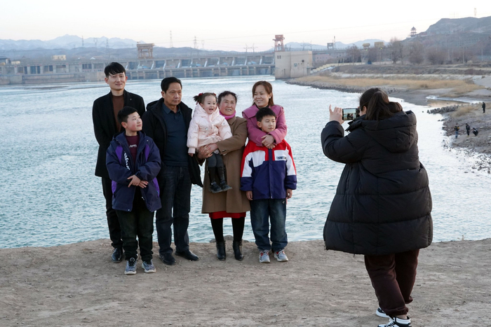一家人在母亲河畔留下幸福的瞬间。