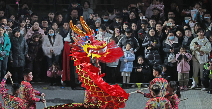 2月11日晚，游客在山东省临沂市郯城县郯国古城景区观看舞龙表演。新华社发（张春雷摄）
