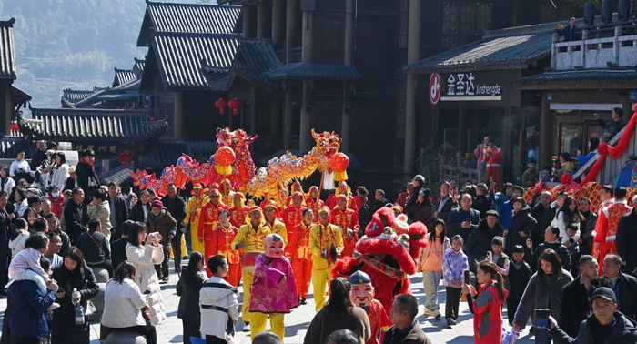 2月11日，重庆市酉阳土家族苗族自治县酉州古城，游客在观看传统龙灯表演。新华社发（邱洪斌摄）