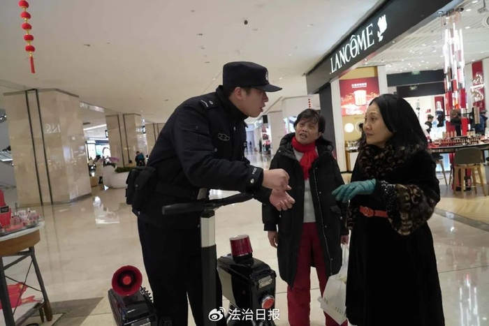 图为湖北省武汉市公安局武昌区分局梅苑派出所民警正在武商梦时代广场内回答群众询问。孙逊 摄