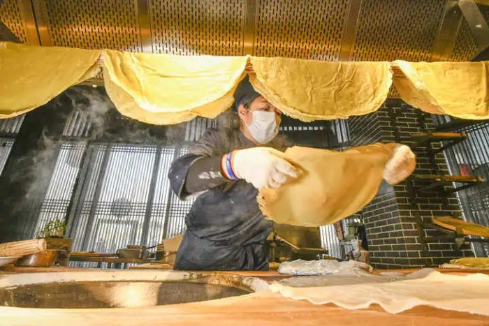 河北唐山宴饹馇加工作坊的工人在加工饹馇盒。新华社发