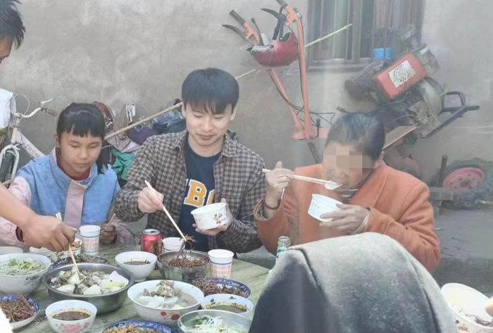 ▲苟永明在四川米易认亲，与母亲一起吃“团年饭”