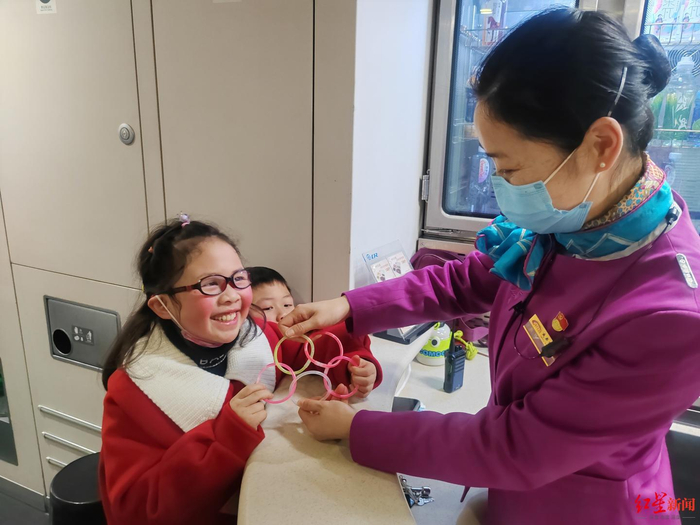 ▲列车员为两名独自出行的小朋友拿玩具