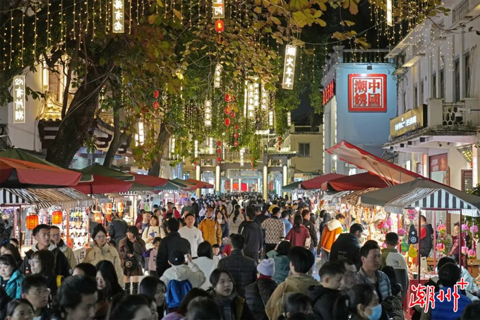 游客在牌坊街文创集市选购潮州特色旅游商品。