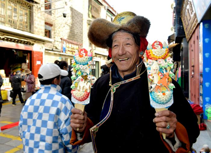 图为：藏族老大爷手里拿着五彩酥油花“孜珠”中新社记者李林摄