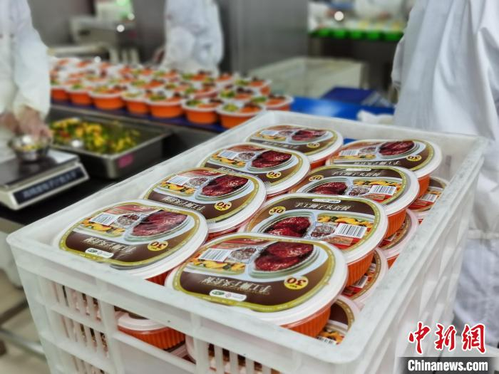 近日,在广新东莞食品分厂的分装车间内,已完成包装的高铁盒饭准备发往