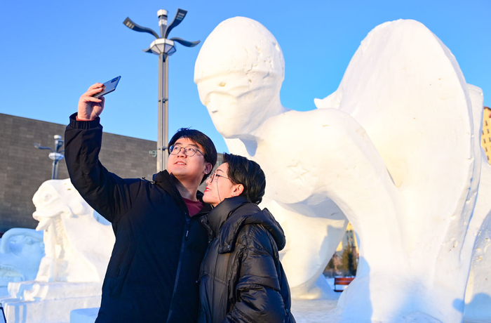　　2月14日，游客在呼伦贝尔历史博物馆广场雪雕前自拍纪念照。王正 摄