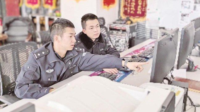 西宁市公安局城东公安分局网安大队民警葛继军（左）和同事查看资料。祁宗珠 摄