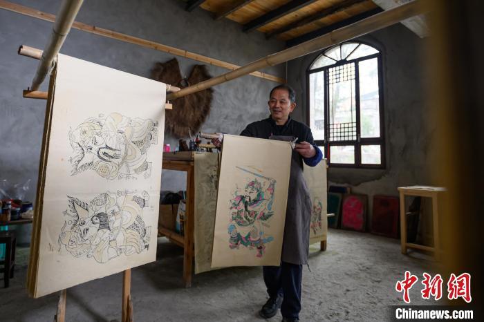 图为工作室内，徐家辉在晾晒印制好的年画。中新网记者 何蓬磊 摄