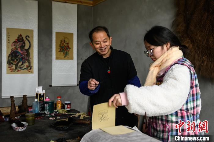 图为工作室内，徐家辉(左)指导学生印制年画。中新网记者 何蓬磊 摄