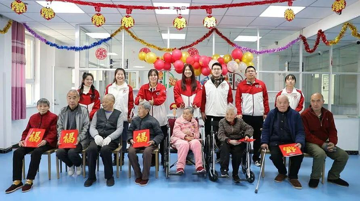 志愿者与老人们一起合影。包伟 摄