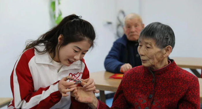志愿者在为老人剪指甲。包伟 摄