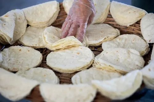 2023年4月30日，山东淄博，高青县一家食品加工企业内，工作人员赶制小饼订单。图/视觉中国