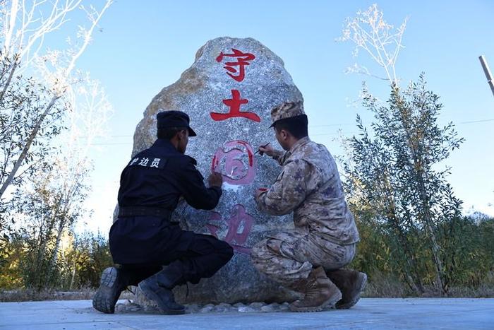 阿里军分区某边防团扎西岗边防连战士和移民管理警察共绘固边石碑