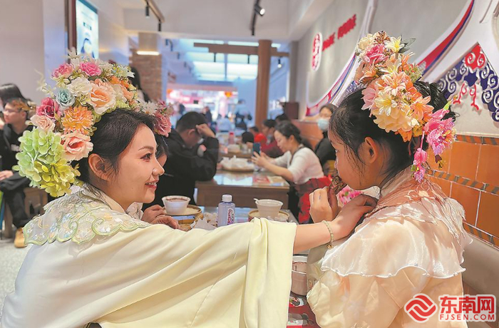 头戴簪花围、身着特色服饰的游客，成为泉州中山路一道亮丽风景。