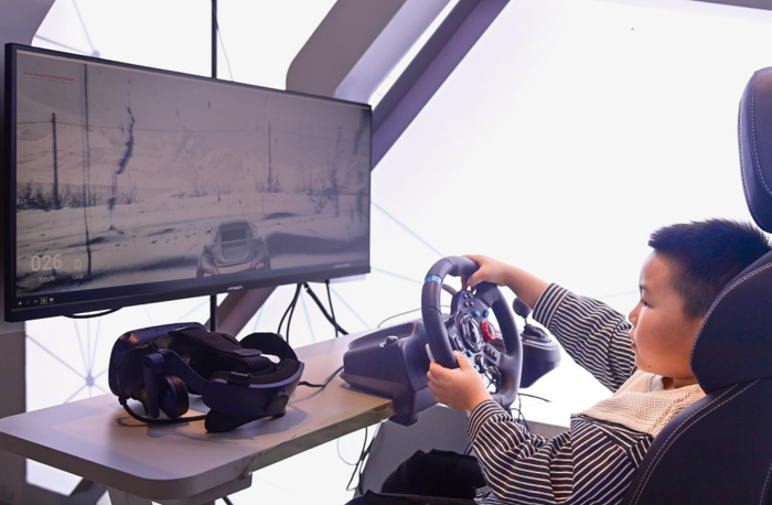 ↑2月14日，小朋友在呼伦贝尔历史博物馆里的互动装置体验冰雪汽车。 王正 摄