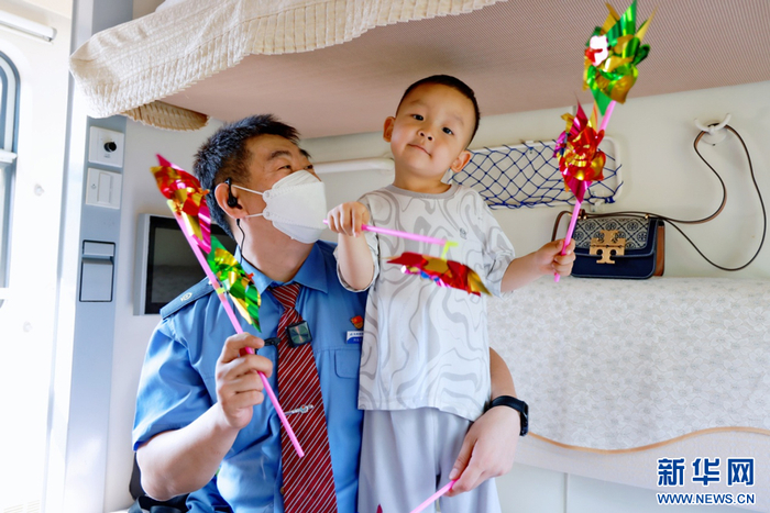 赫军将自己制作的风车送给小朋友