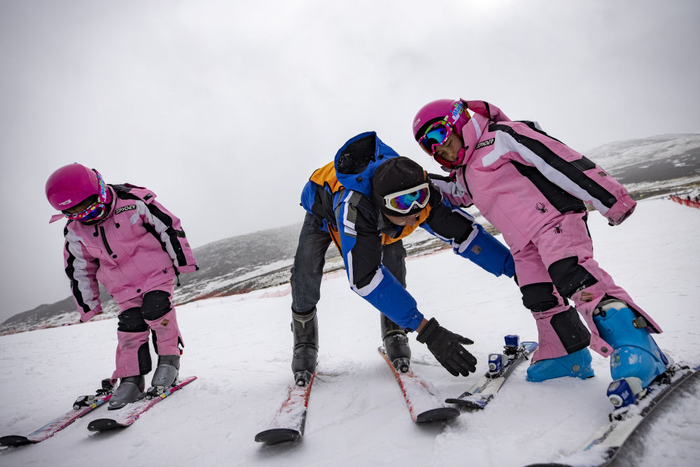 多滑雪场,欧珠卓玛(左),平措卓玛(右)在教练洛桑平措的帮助下学习滑雪