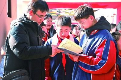 光明日报记者韩业庭（左一）在山东峄城采访当地小学生。孙慧摄/光明图片