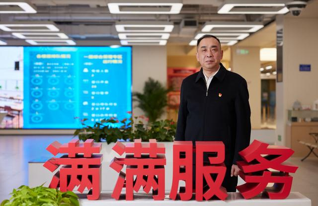 1月31日，丰台区政务服务中心大厅，陈焰站在“满满服务”的标语后。  新京报记者 郭延冰 摄