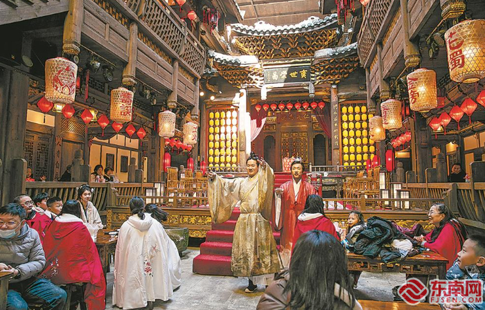 今年春节，长汀文旅地标之一的八喜楼重装上新，新增“八喜”原创唐宋古风剧情演绎。图为游客观看客家“八喜”剧场小品。