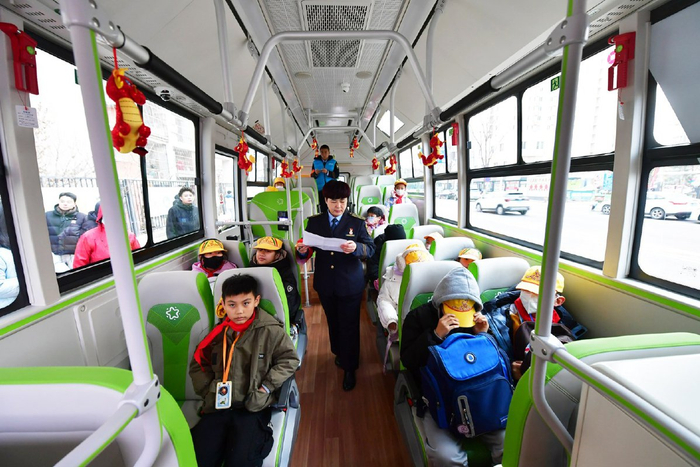 通学公交上，乘务员核对名单。记者 常鸣/摄