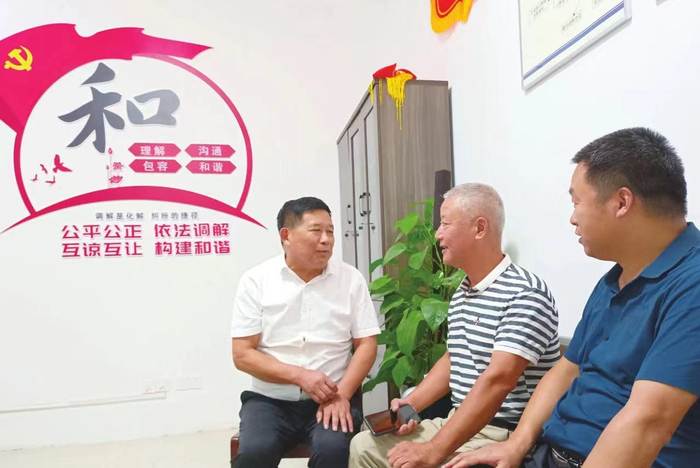 杨传武（左一）在工作室接待来访群众。