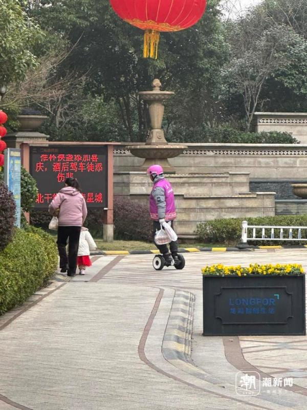 小区物业的规定快递三轮车不得入内，骑手用平衡车辅助送货。记者章然/摄