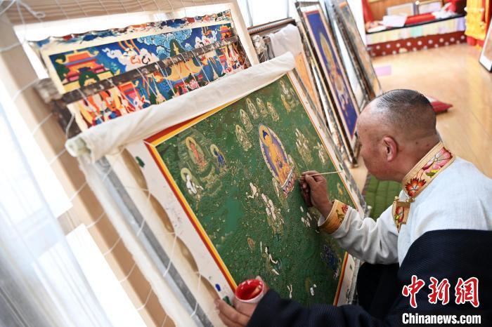 图为交巴加布在个人工作室为唐卡上色。他的作品色彩鲜艳而不失和谐，线条流畅而富有张力，展现了深厚的艺术造诣。九美旦增 摄