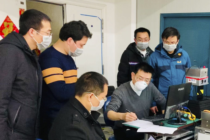 黄立（右三）与科研人员在高德红外生产调试车间忙碌（2020年2月11日摄）。新华社发
