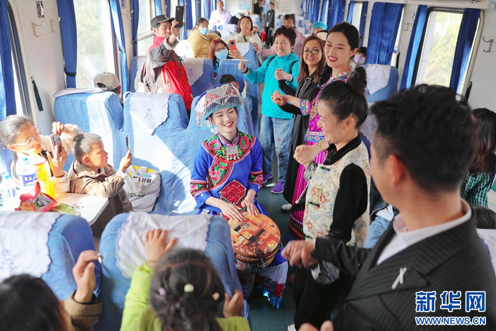 昆明开往罗平的列车上，身着民族服饰的乘务员为旅客带来手鼓表演（摄于2月22日）。新华网发（杨紫轩 摄）