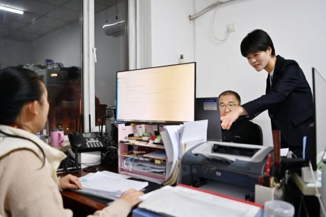 天津市河西区委组织部干部张卓（右一）在工作中（2024年1月25日摄）。新华每日电讯记者李然 摄