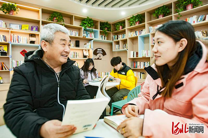 2月26日，南文营社区党群服务中心社区会客厅，刘炳辉（左一）在图书角进行阅读分享。 河北日报记者 刘光昱摄