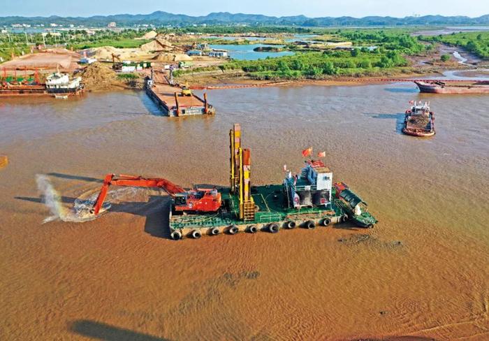  2023年10月3日，施工机械在平陆运河入海口段进行疏浚作业。图/新华