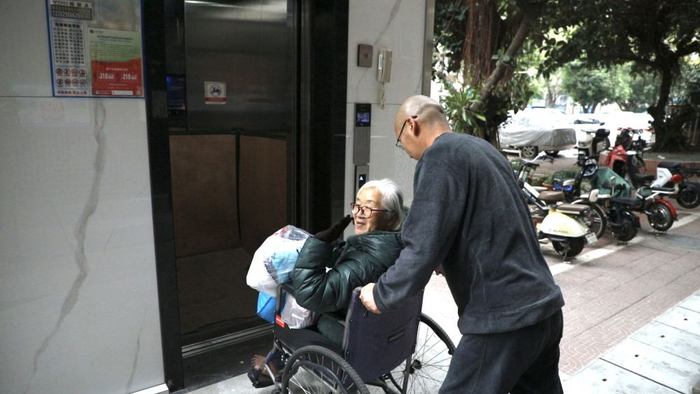 69691月24日,在深圳龙岗区龙城街道长江花园小区,坐在轮椅上的