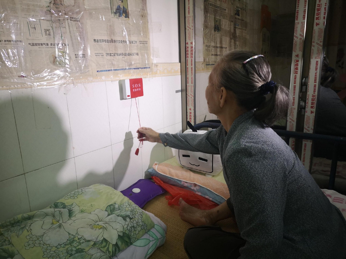 资料图：居家适老化改造，为老人在床边安装SOS报警器。记者 王洪旭 摄