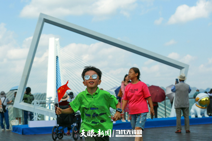 游客在贵州省平塘县天空之桥观光服务区游玩.