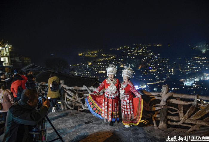 今年西江千户苗寨的旅拍生意爆火，图为游客在观景台打卡拍照。