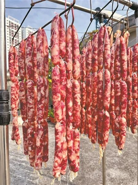 资料图：不少市民在楼顶、阳台晾晒腊肉、腊肠等。